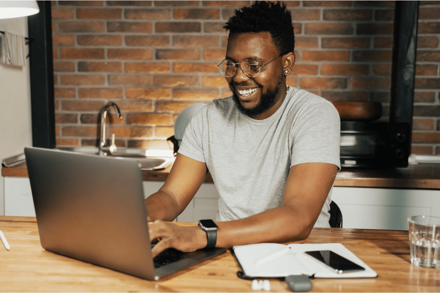 person happily typing on computer in a kitchen